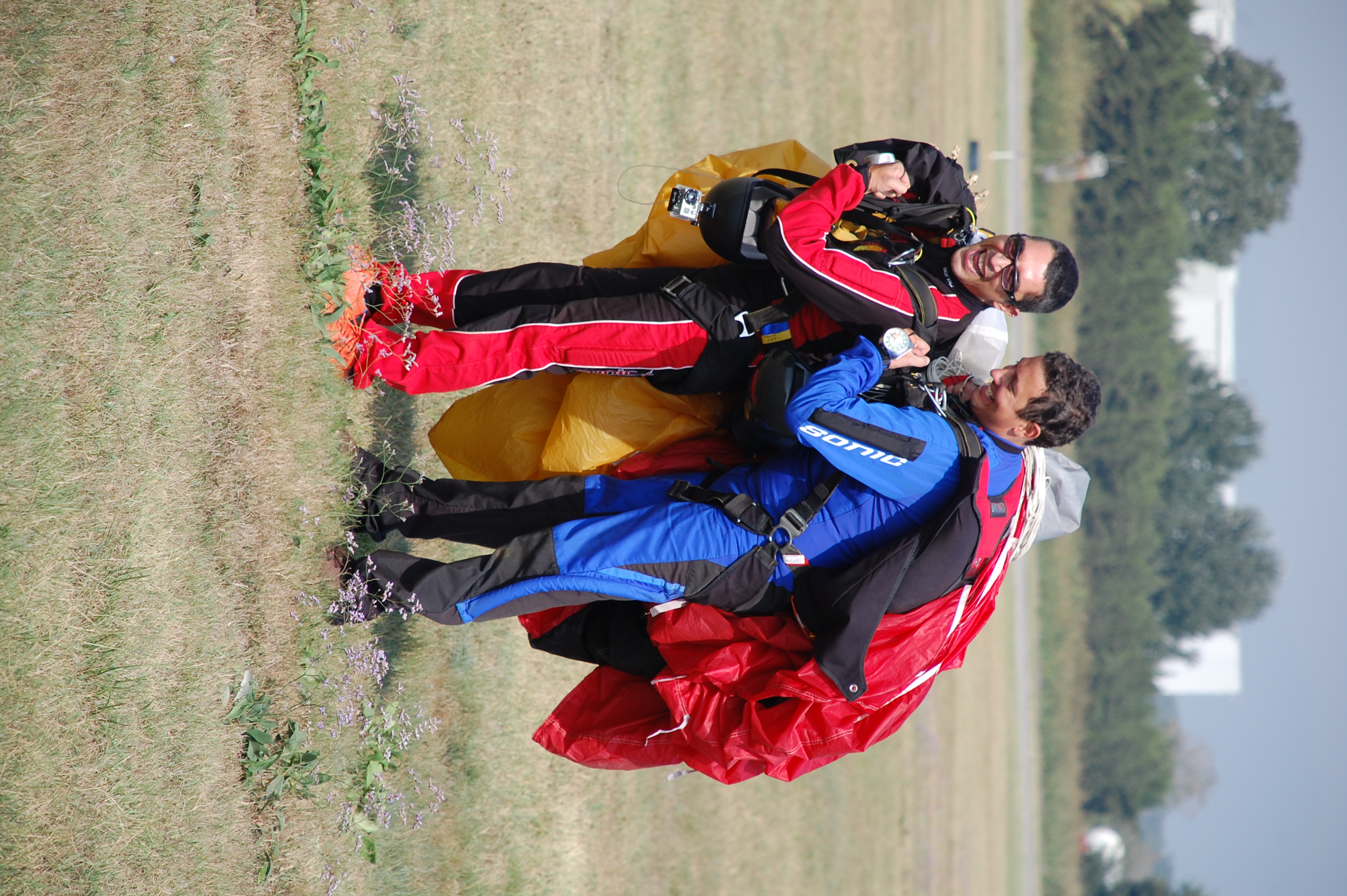 Team posing with parachute gear at the airfield